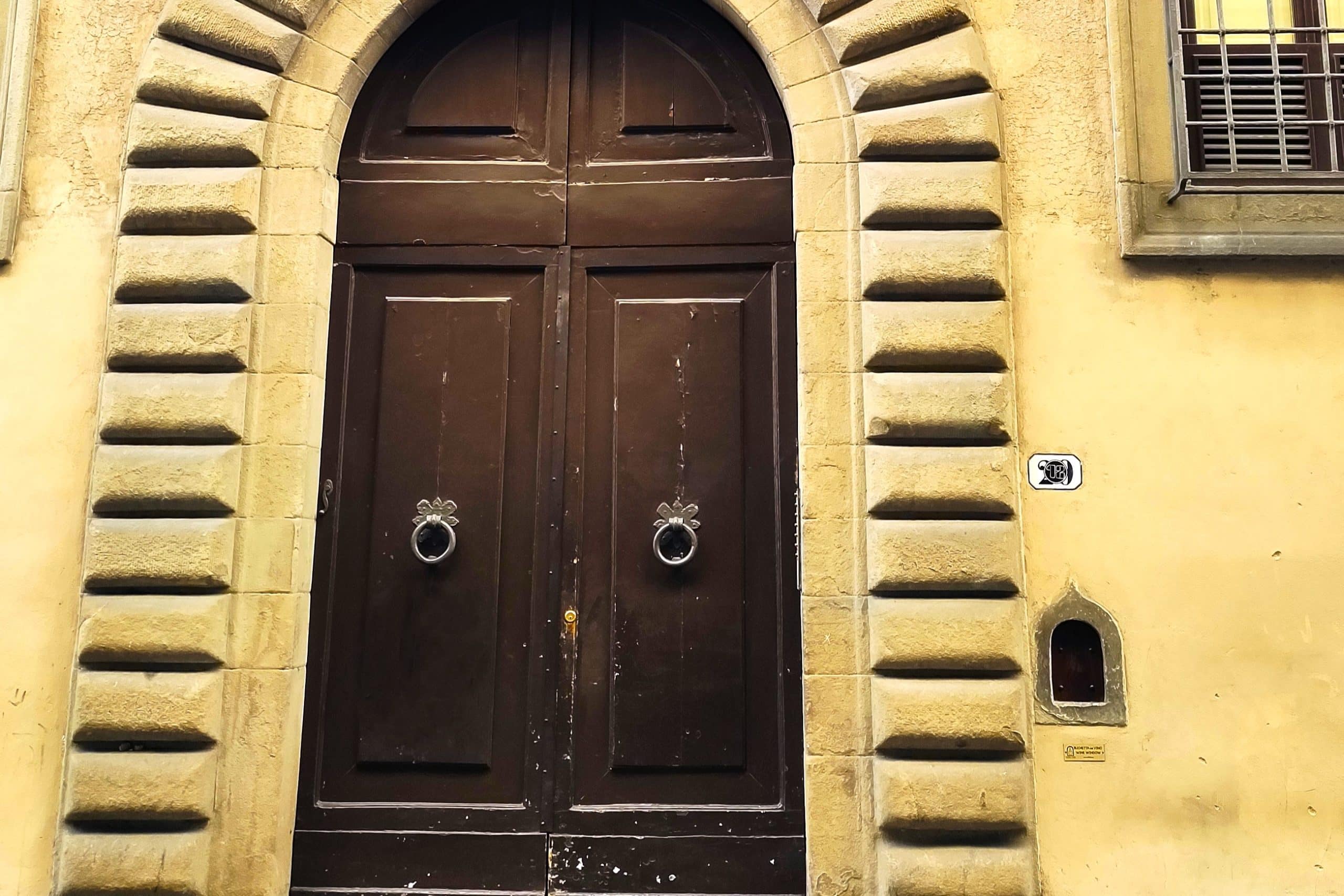 Little door for the wine and entrance door of a building in Florence